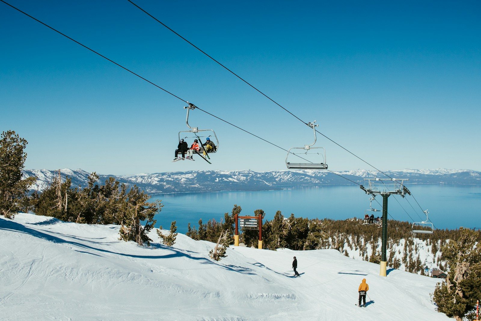 a group of people riding skis down a snow covered slope. lake Tahoe skiing