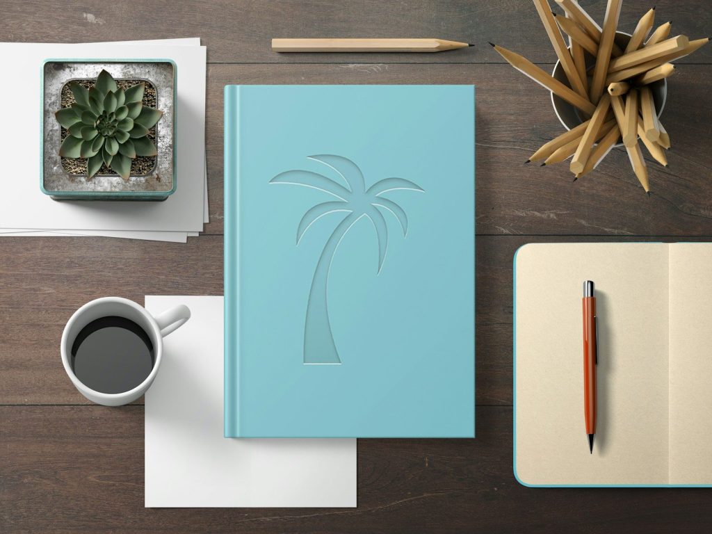 a notebook with a palm tree cut out of it next to a cup of coffee how to contribute travel stories to California Travel insider